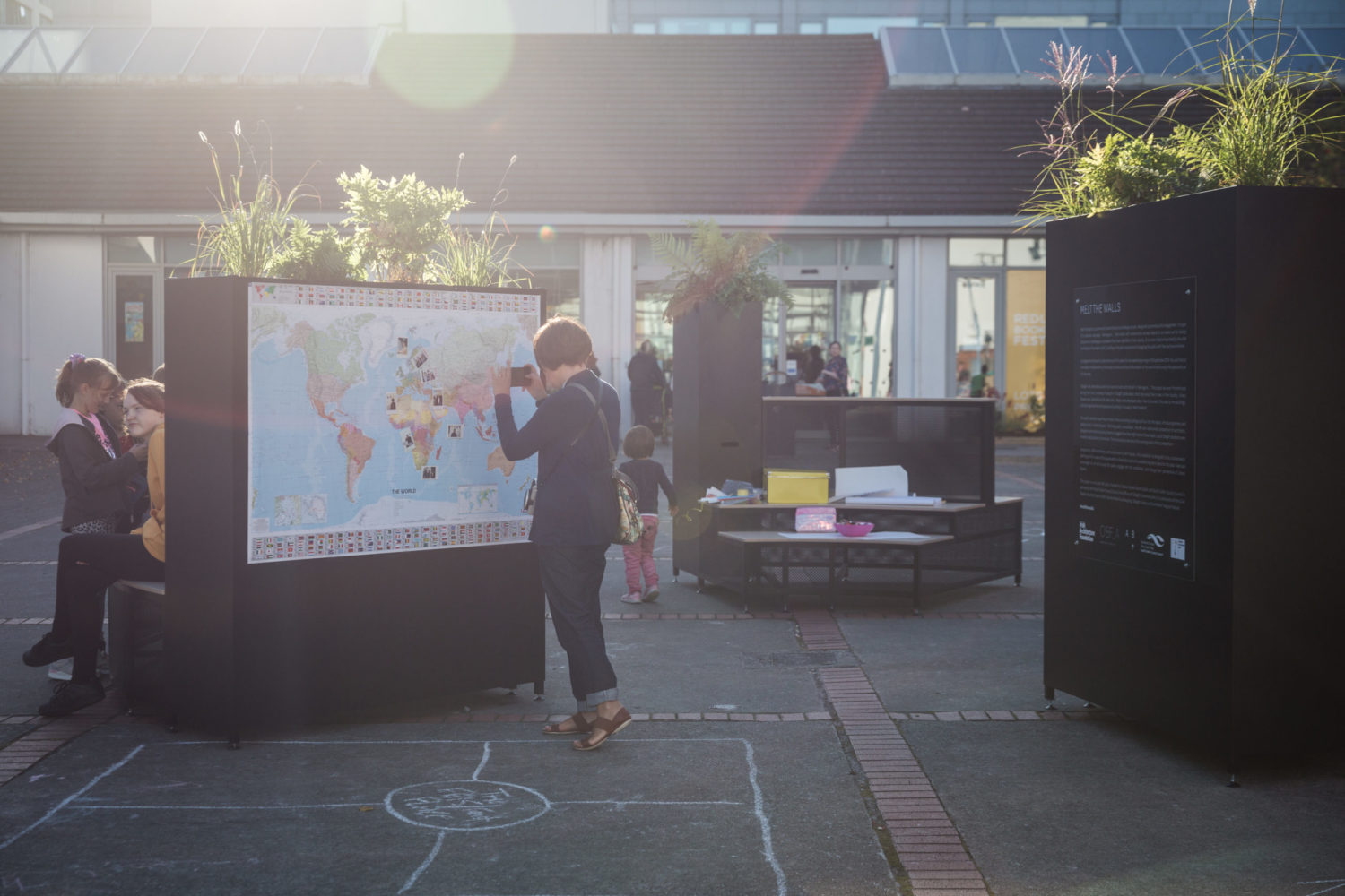 Person Standing in Front of Map, taking a photo. Map is part of an architectural installation in a public square.